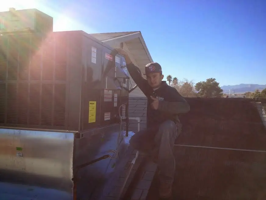 HVAC technician performing AC Tune-Up on a rooftop unit in Rancho Calaveras